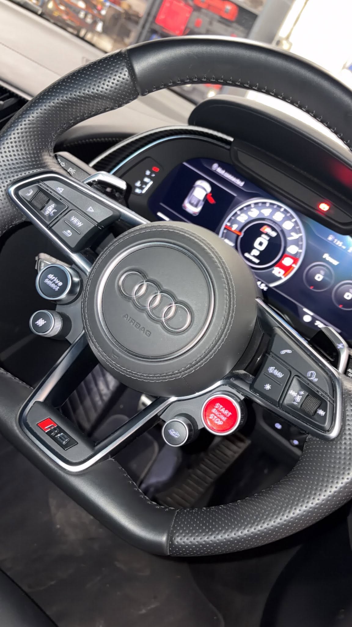 The steering wheel and digital dashboard of an Audi in for work