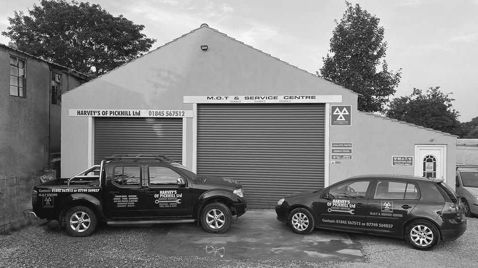 The Harvey's of Pickhill workshop frontage with its M.O.T & Service Centre sign and two liveried vehicles